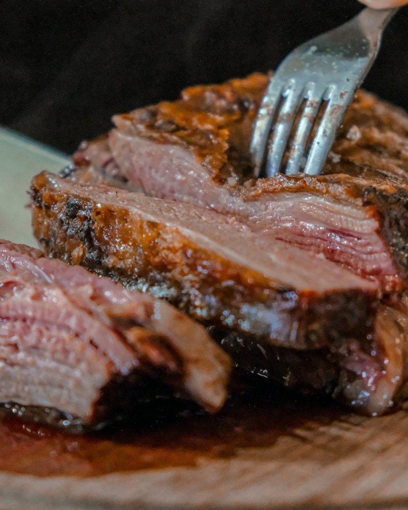 Lomo de vaca a la brasa cortado en lonchas, rosado por dentro